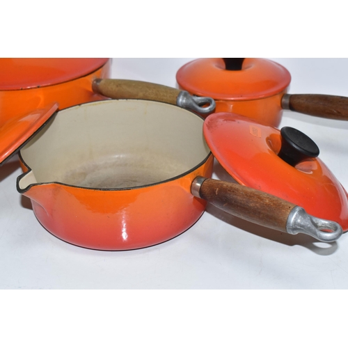 793 - THREE VINTAGE LE CREUSET PANS WITH TWO EXTRA LIDS in 'Volcanic Orange' colours all with wooden handl... 