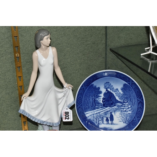 802 - A GROUP OF CERAMICS AND ENAMEL TRINKET BOXES, ETC, comprising a Nao figure of a lady holding her ski... 