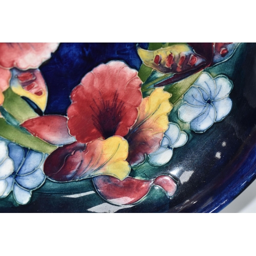 814 - A MOORCROFT POTTERY 'ORCHID' PATTERN FOOTED BOWL, tube-lined with a ring of red, yellow and purple o... 