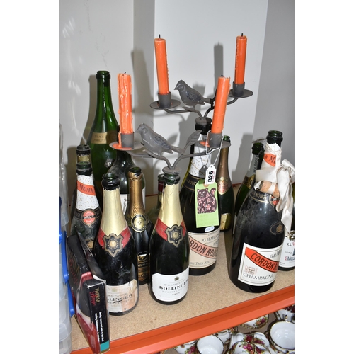 826 - A COLLECTION OF CANDLESTICK ADAPTED BOTTLES AND SPARE MOSTLY CHAMPAGNE BOTTLES to include a Bollinge... 