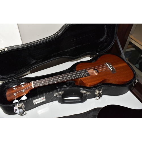 851 - A UKELELE AND A 3/4 SIZE LEFT-HANDED GUITAR, both have cases, comprising a Laka ukelele with built i... 