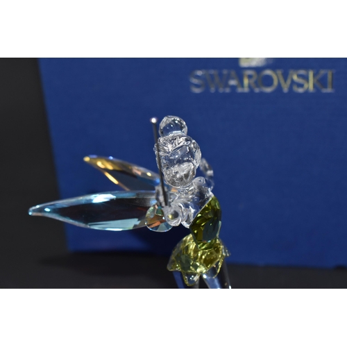 871 - A BOXED SWAROVSKI CRYSTAL 'TINKERBELL' SCULPTURE mounted on a frosted glass base, with iridescent wi... 