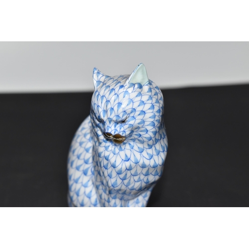 876 - A HEREND BLUE FISHNET FIGURE OF A SEATED CAT, model no. 5853, gilt detail to muzzle and paws, light ... 