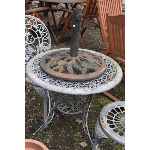 18 - AN OVERPAINTED CAST ALUMINIUM GARDEN TABLE, diameter 65cm x height 62cm, two chairs and a cast iron ... 
