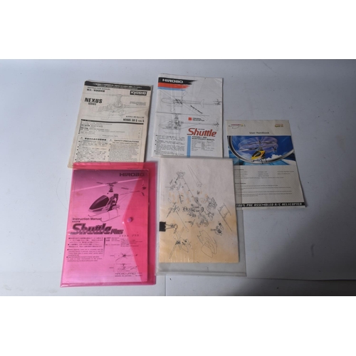 174 - SIX TRAYS CONTAINING RC HELICOPTER PARTS including nose cones, tail rods, rotors, engine parts, manu...