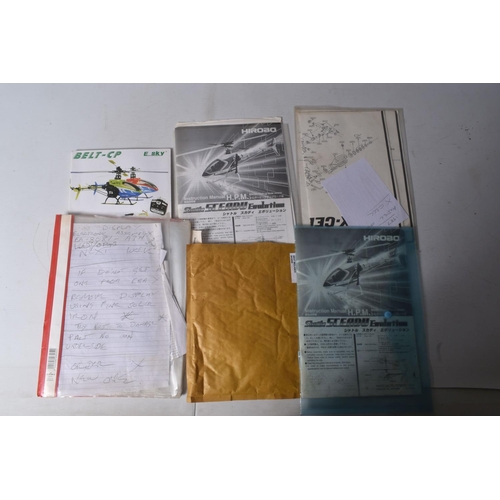 174 - SIX TRAYS CONTAINING RC HELICOPTER PARTS including nose cones, tail rods, rotors, engine parts, manu...
