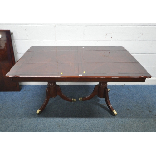 166 - A REPRODUCTION MAHOGANY TWIN PEDESTAL DINING TABLE, with one additional leaf, each leg with brass ca... 