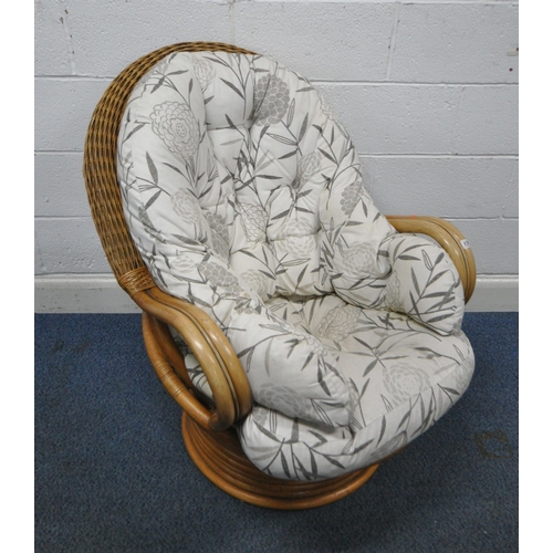 176 - A RATTAN SWIVEL ROCKING CHAIR, with foliate upholstery, width 77cm x depth 97cm x height 96cm, condi... 