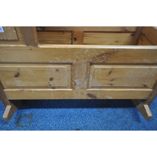 191 - A LATE 20TH CENTURY PINE ROCKING CRIB, with a raised back and hood, length 95cm x depth 54cm x heigh... 