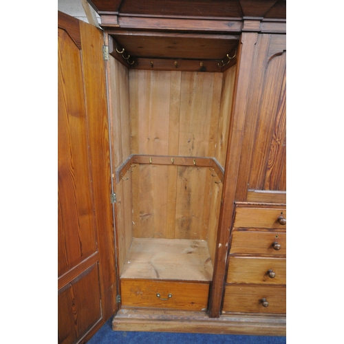 151 - A 19TH CENTURY PITCH PINE WARDROBE, fitted with two large doors, flanking smaller double doors over ... 