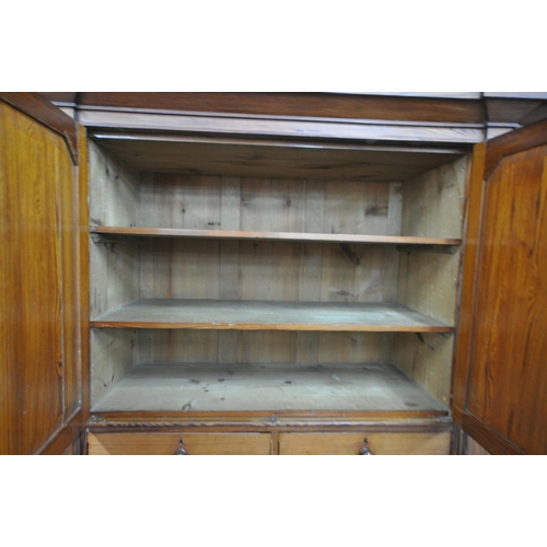 151 - A 19TH CENTURY PITCH PINE WARDROBE, fitted with two large doors, flanking smaller double doors over ... 