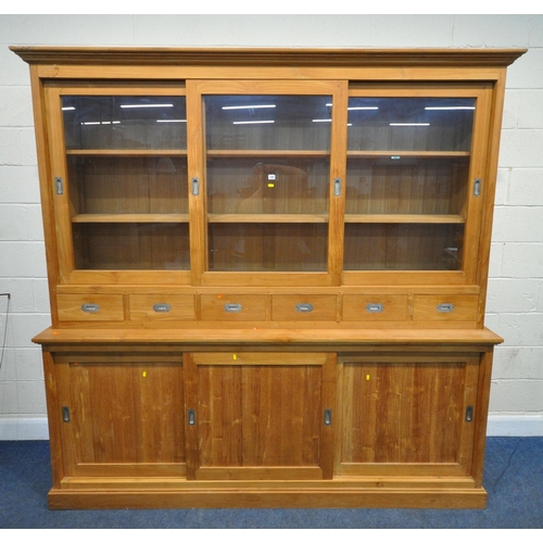 185 - A LARGE MODERN OAK HOUSEKEEPERS CUPBOARD, fitted with triple glass sliding doors, six drawers, atop ... 