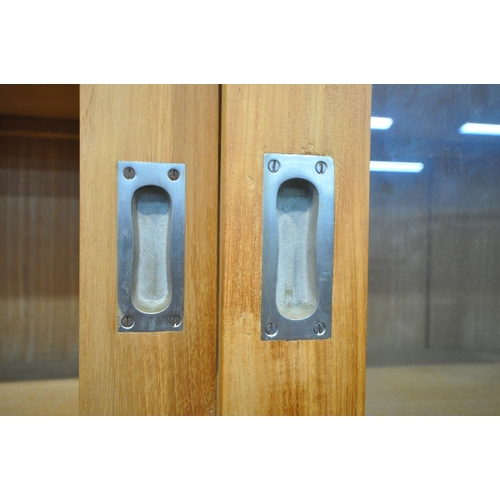 185 - A LARGE MODERN OAK HOUSEKEEPERS CUPBOARD, fitted with triple glass sliding doors, six drawers, atop ... 