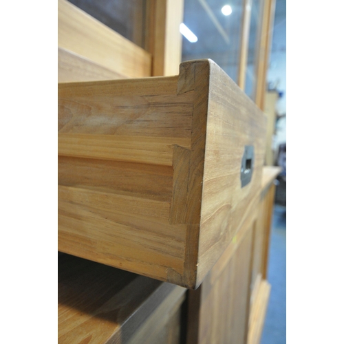 185 - A LARGE MODERN OAK HOUSEKEEPERS CUPBOARD, fitted with triple glass sliding doors, six drawers, atop ... 