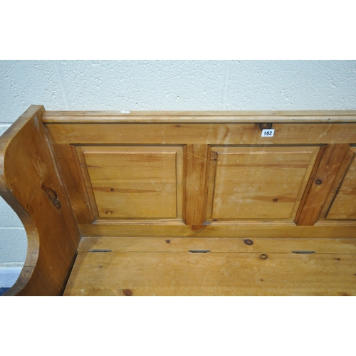 182 - A MODERN PINE SETTLE, with shaped armrests, flanking a hinged seat, width 128cm x depth 46cm x heigh... 