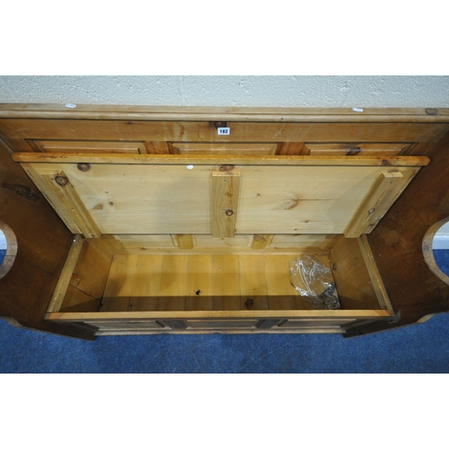 182 - A MODERN PINE SETTLE, with shaped armrests, flanking a hinged seat, width 128cm x depth 46cm x heigh... 