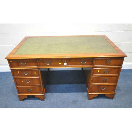 211 - A REPRODUCTION YEW WOOD TWIN PEDESTAL DESK, with a green leather writing surface, fitted with an arr... 