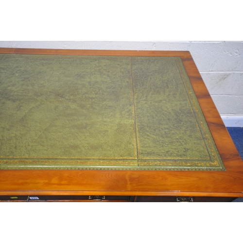 211 - A REPRODUCTION YEW WOOD TWIN PEDESTAL DESK, with a green leather writing surface, fitted with an arr... 