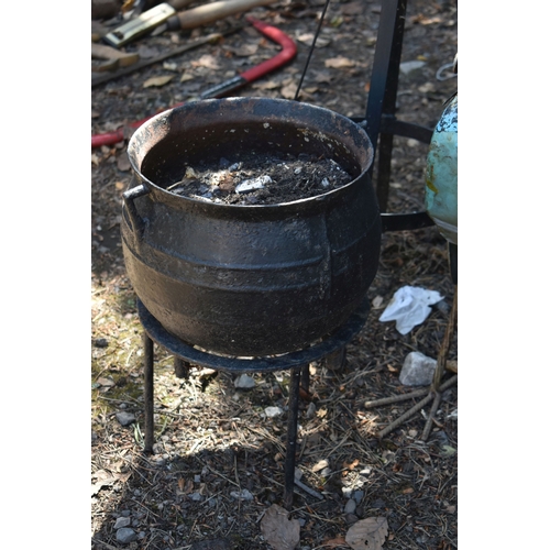 6 - A SELECTION OF METALWARE, to include a cast iron cauldron type cooking pot, a separate stand, a tall...
