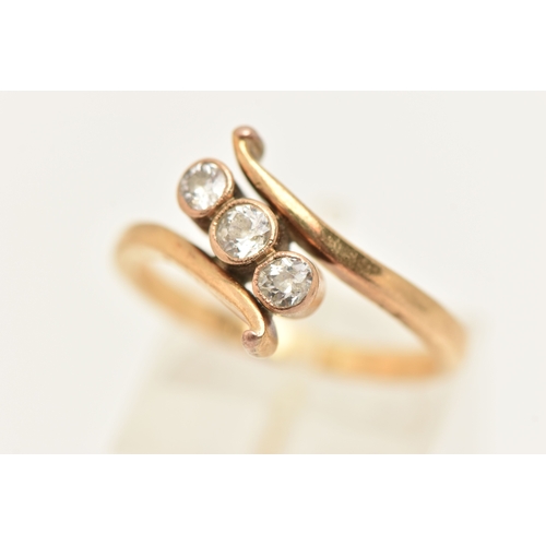 A YELLOW METAL THREE STONE DIAMOND RING, designed as three milgrain ...