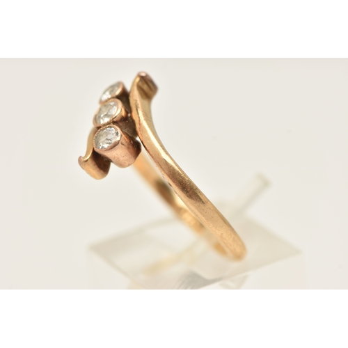 A YELLOW METAL THREE STONE DIAMOND RING, designed as three milgrain ...