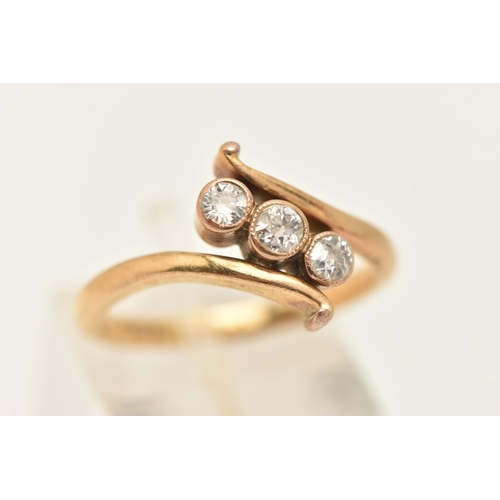 A YELLOW METAL THREE STONE DIAMOND RING, designed as three milgrain ...