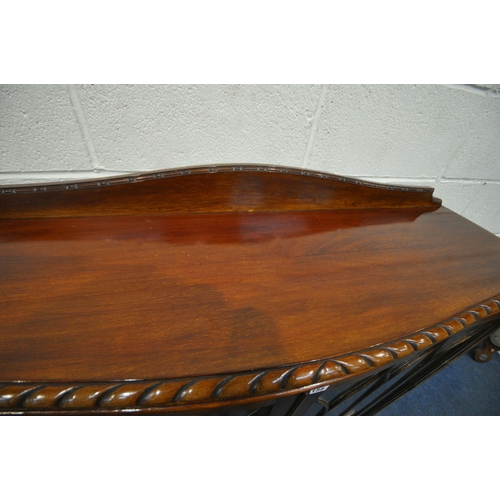 155 - AN EARLY 20TH CENTURY MAHOGANY SERPENTINE BOOKCASE, with a raised back, double glazed doors, raised ... 