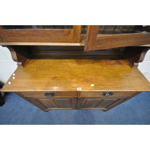 167 - AN ARTS AND CRAFTS OAK DRESSER, the double glass door enclosing three shelves, atop a base with two ... 