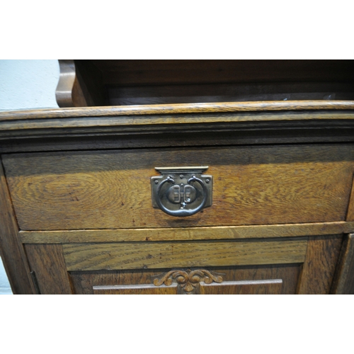 167 - AN ARTS AND CRAFTS OAK DRESSER, the double glass door enclosing three shelves, atop a base with two ... 