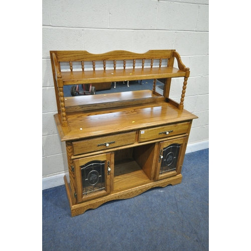 171 - AN OAK MIRROR BACK SIDEBOARD, with turned spindles and supports, two drawers over two lead glazed do... 