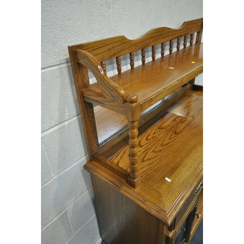 171 - AN OAK MIRROR BACK SIDEBOARD, with turned spindles and supports, two drawers over two lead glazed do... 