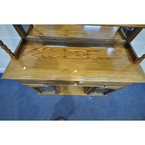 171 - AN OAK MIRROR BACK SIDEBOARD, with turned spindles and supports, two drawers over two lead glazed do... 
