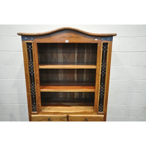195 - A MANGO WOOD CABINET, with an arched top, iron details, two shelves, two drawers and double cupboard... 