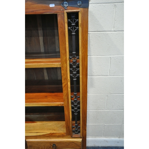 195 - A MANGO WOOD CABINET, with an arched top, iron details, two shelves, two drawers and double cupboard... 