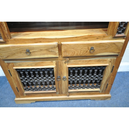 195 - A MANGO WOOD CABINET, with an arched top, iron details, two shelves, two drawers and double cupboard... 