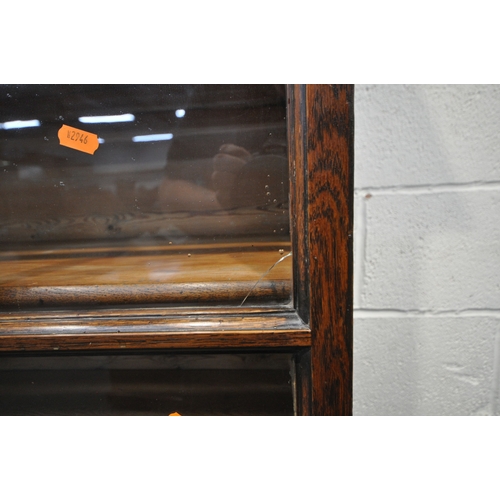 218 - AN OAK CABINET ON STAND, the double glass doors enclosing two shelves and four drawers, width 125cm ... 