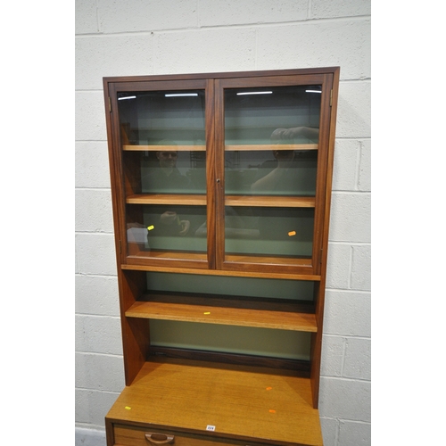 224 - G PLAN, A MID-CENTURY TEAK WALL CABINET, with double glass doors, atop a base with a single drawer, ... 