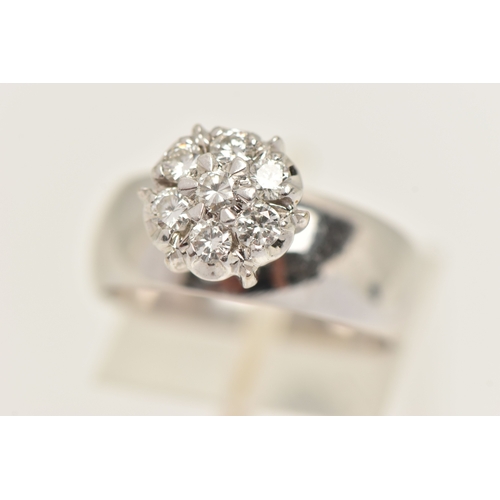 402 - A DIAMOND CLUSTER RING, seven round brilliant cut diamonds, prong set in white metal, approximate to... 