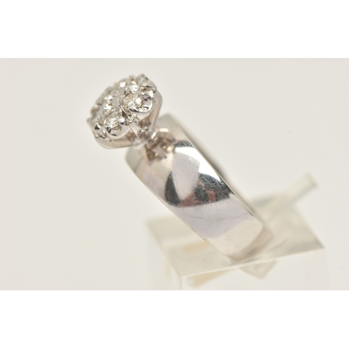 402 - A DIAMOND CLUSTER RING, seven round brilliant cut diamonds, prong set in white metal, approximate to... 