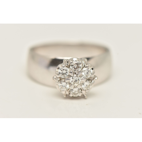 402 - A DIAMOND CLUSTER RING, seven round brilliant cut diamonds, prong set in white metal, approximate to... 