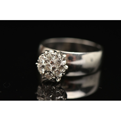 402 - A DIAMOND CLUSTER RING, seven round brilliant cut diamonds, prong set in white metal, approximate to... 