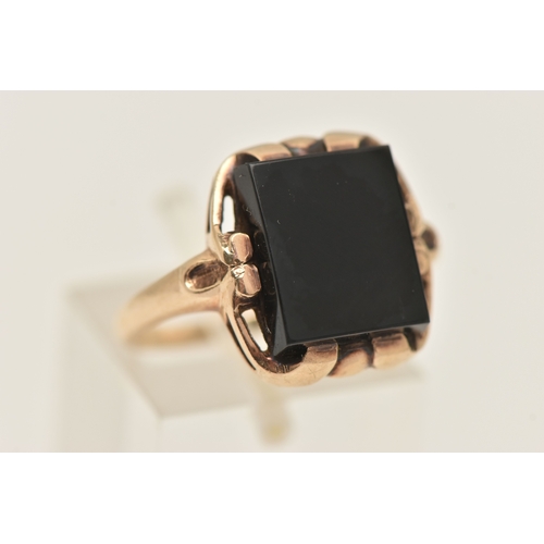 404 - A YELLOW METAL GEM SET RING, a rectangular cut onyx, prong set in yellow metal with slightly tapered... 