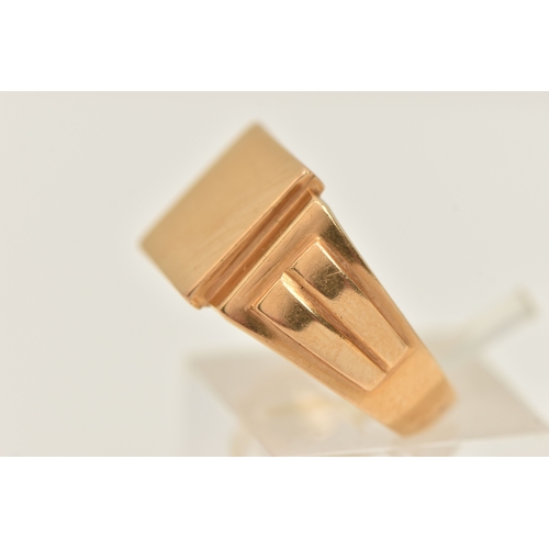 416 - A GENTS YELLOW METAL SIGNET RING, of a square polished form, textured shoulders and a polished band,... 