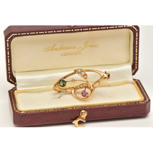 428 - A CASED YELLOW METAL GEM SET BROOCH, of an open work design, set with a pink and a green tourmaline ... 