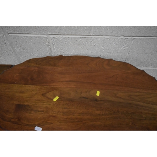 223 - A 20TH CENTURY OVAL TABLE, with a wavy edge, raised on four shaped legs, united by an undershelf, wi...