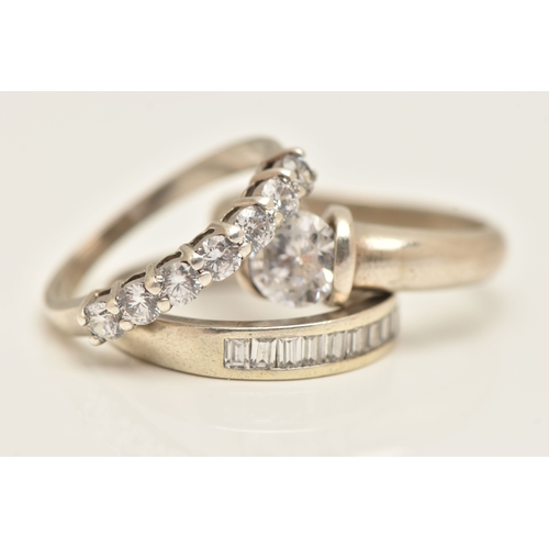 THREE WHITE METAL RINGS, to include a seven stone cubic zirconia ring ...