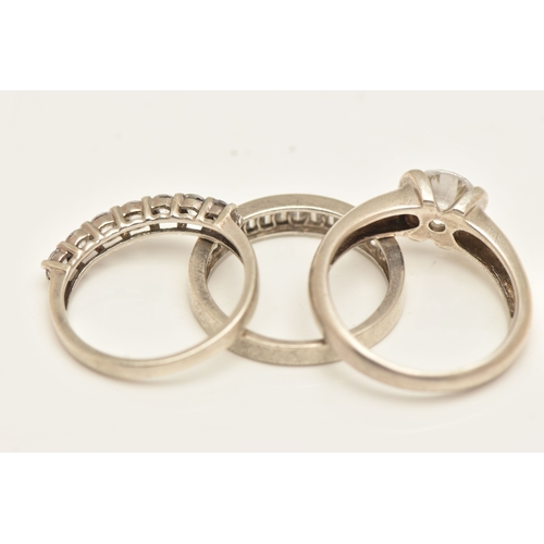 THREE WHITE METAL RINGS, to include a seven stone cubic zirconia ring ...