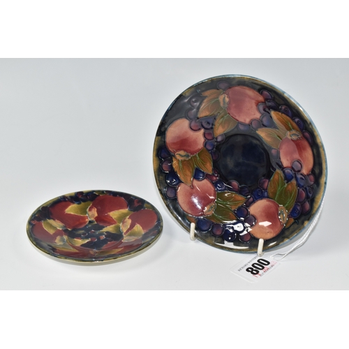 800 - TWO PIECES OF MOORCROFT POTTERY, a saucer featuring tube lined pomegranate pattern, diameter 13.5cm,... 