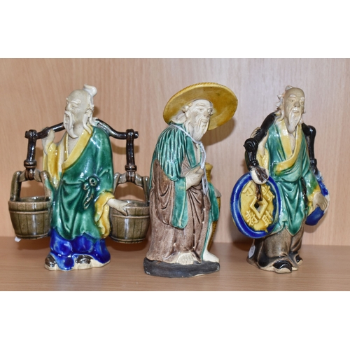 816 - A GROUP OF THREE CHINESE EXPORT MUD MEN FIGURES comprising two different figures carrying items with... 