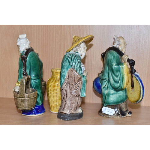 816 - A GROUP OF THREE CHINESE EXPORT MUD MEN FIGURES comprising two different figures carrying items with... 